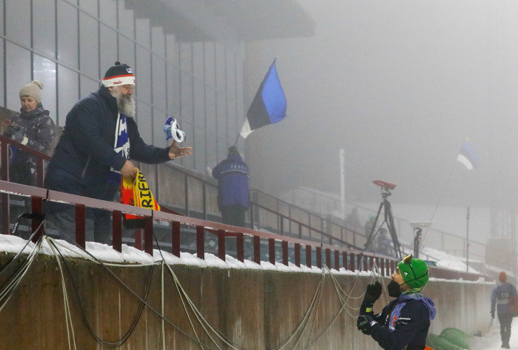 Fabian Rießle schenkt einem Estnischen Fan sein Bib. Dieser Fan ist regelmäßiger Gast bei Wettkämpfen der Kombinierer.