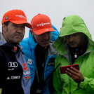 Horst Hüttel (DSV), Rendirektor Lasse Ottesen (FIS) und Kontrolleur Guntram Kraus (FIS) schauen im Zielbereich per Livestream das Rennen.