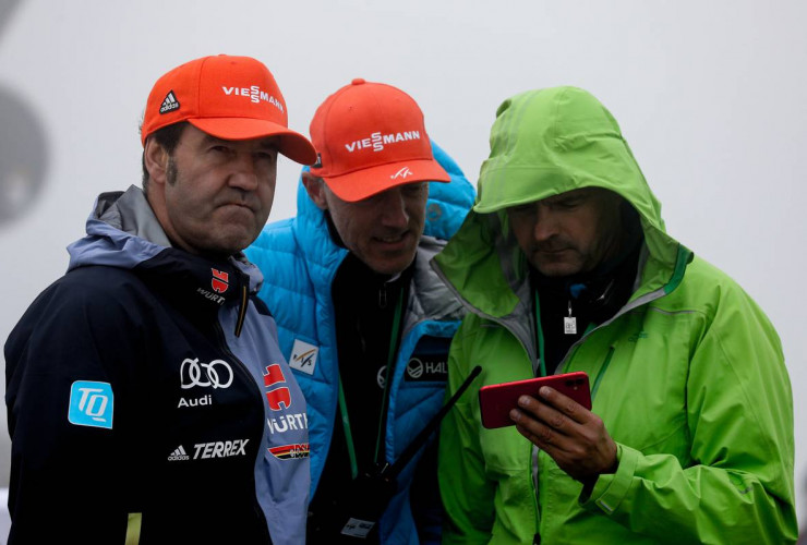 Horst Hüttel (DSV), Rendirektor Lasse Ottesen (FIS) und Kontrolleur Guntram Kraus (FIS) schauen im Zielbereich per Livestream das Rennen.