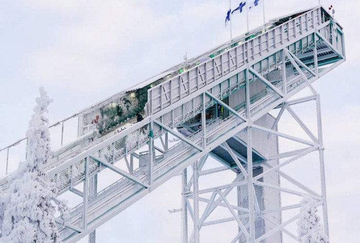 Die finnischen Fahnen stehen im Wind auf der Schanze am Rukatunturi.