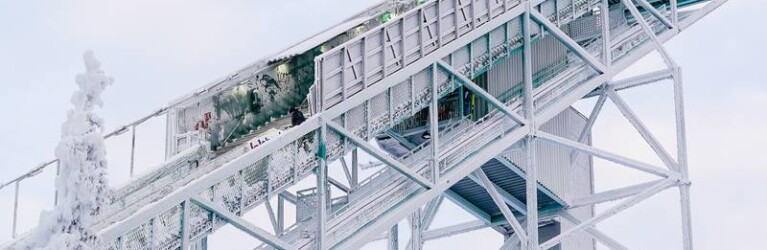 Die finnischen Fahnen stehen im Wind auf der Schanze am Rukatunturi.