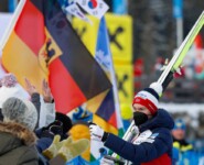 Jens Luraas Oftebro (NOR) verteilt Autogrammkarten in Seefeld.