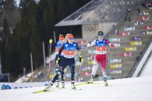 Jenny Nowak (GER) und Yuna Kasai (JPN) (l-r)laufen mit aufgemaltem Bart vor den Olympischen Ringen.
