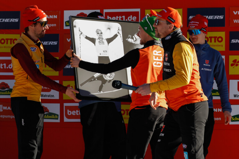 Die Teamkollegen überreichen Fabian Riessle (GER) eine Bildercollage zum Abschied.