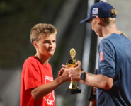 Jens Luraas Oftebro (NOR) übergibt den Preis an Liam Demong (USA), Sohn des Olympiasiegers Billy Demong (USA).