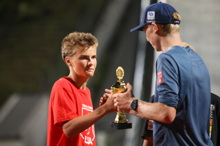 Jens Luraas Oftebro (NOR) übergibt den Preis an Liam Demong (USA), Sohn des Olympiasiegers Billy Demong (USA).